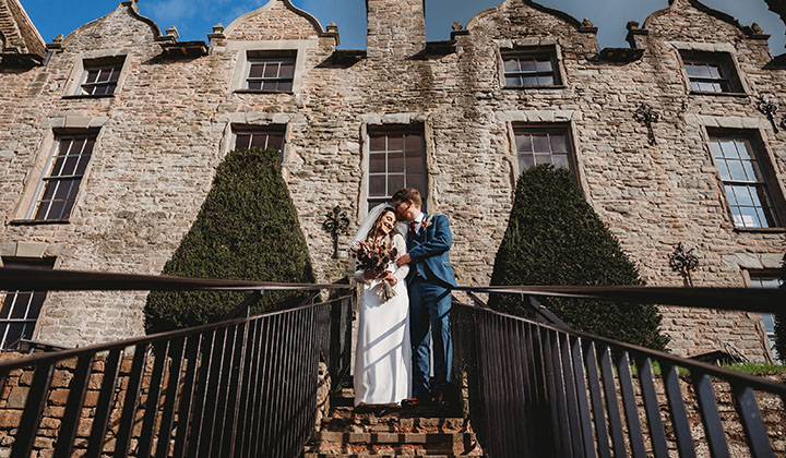 Bride and groom on the steps of Hay Castle
